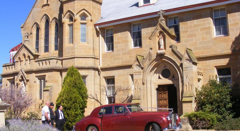 a red car parked in front of a church, Abbey Boutique Hotel in Warwick