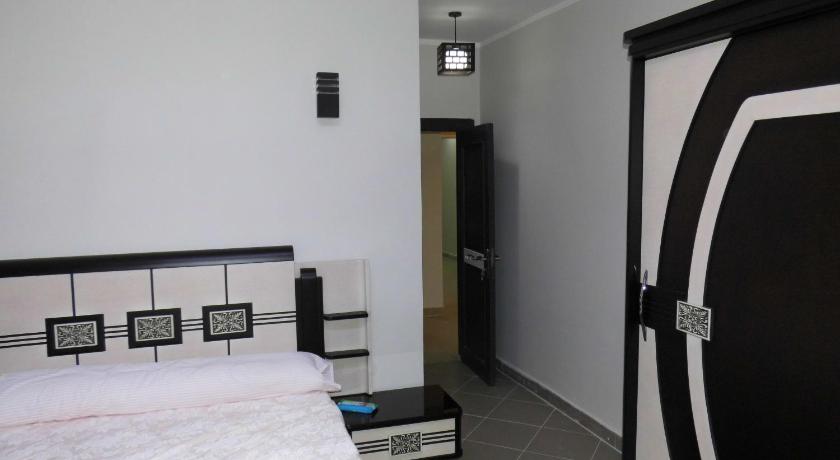 a hotel room with a bed, chair, and nightstand, Three-Bedroom Apartment at Louly Beach Resort in Ataqah