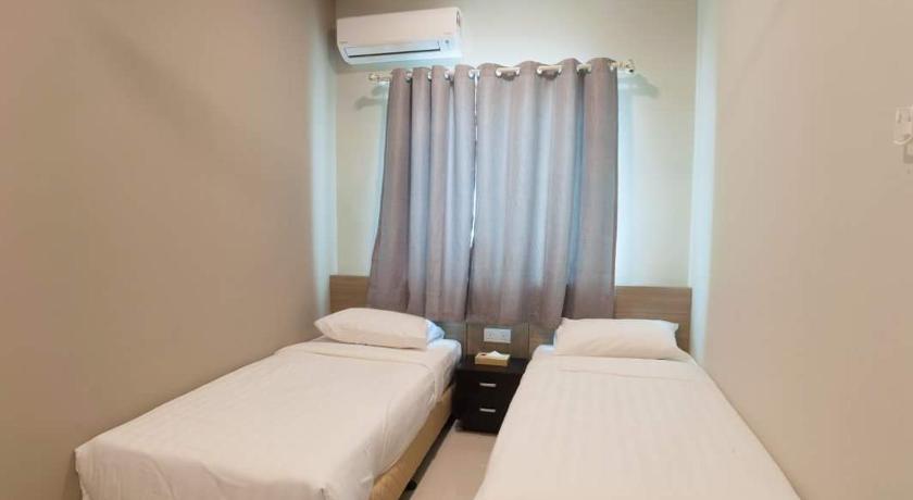 a hotel room with two beds and two windows, C Residence Labuan in Labuan