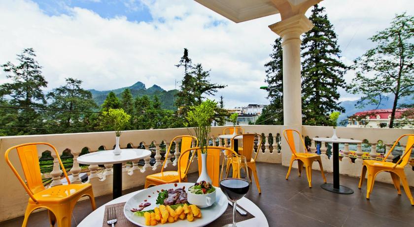 a restaurant with tables and chairs and a patio area with umbrellas, Lacasa Sapa Hotel in Sapa