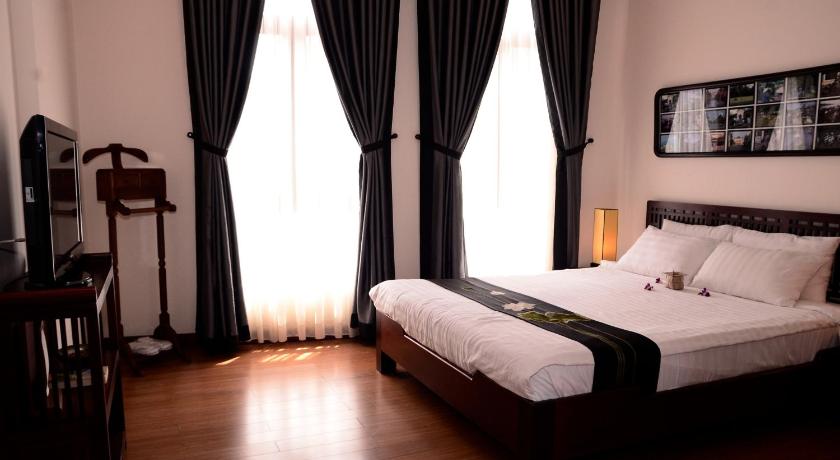 a bedroom with a large bed and a large window, Nam Bo Boutique Hotel in Cần Thơ