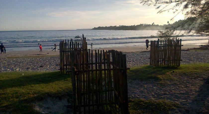 a wooden fence on a beach with people walking on it, Pondok Oma in Matanurung