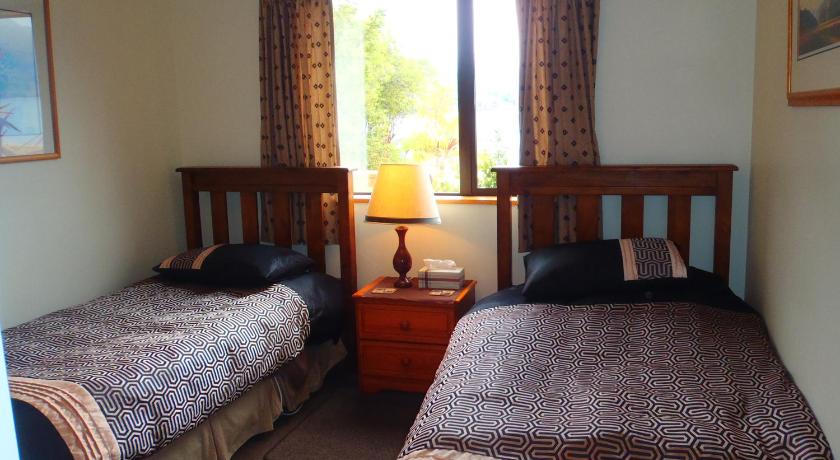 a bedroom with two beds and two lamps, Lakefront Bellevue Lake Hawea Wanaka in Wanaka