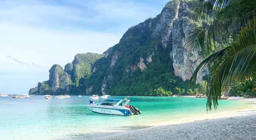 a small boat on a beach near a large body of water, Phi Phi Maiyada Resort (SHA Certified) in Ko Phi Phi