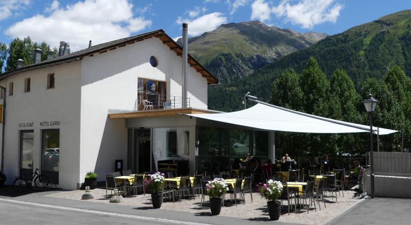 a row of tables with umbrellas in front of a building, Laagers Hotel Garni in Samedan