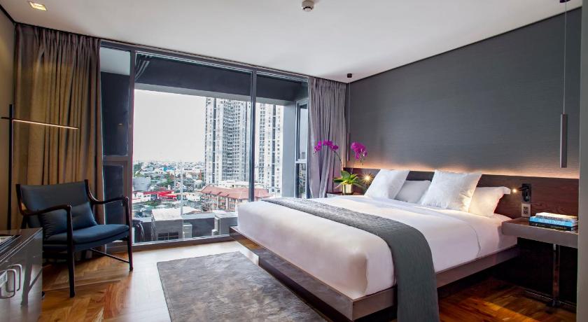 a bedroom with a large bed and a large window, Ramada Encore Makati in Manila