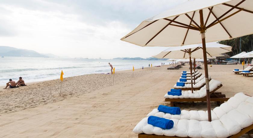 a beach with chairs and umbrellas on the sand, StarCity Nha Trang Hotel in Nha Trang