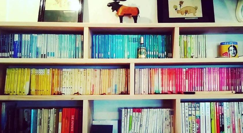 a bookshelf filled with books on top of each other, Guesthouse Sofusha in Takeo