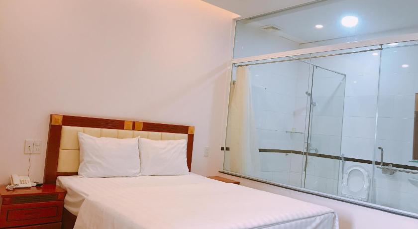 a hotel room with a bed and a dresser, Hoang Ngoc Hotel in Pleiku (Gia Lai)