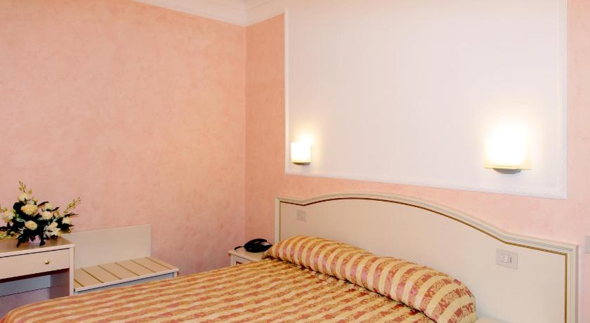 a hotel room with two beds and a lamp, Hotel divino Amore in Bagnoregio