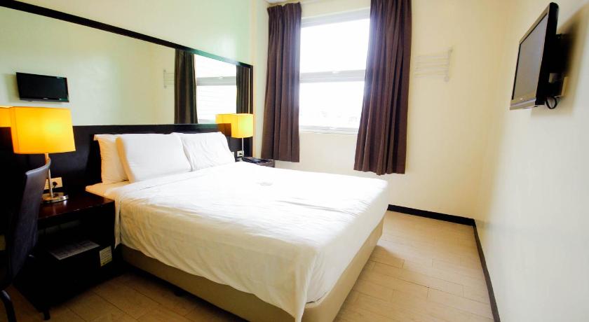 a hotel room with a large bed and a large window, Go Hotels Puerto Princesa in Palawan