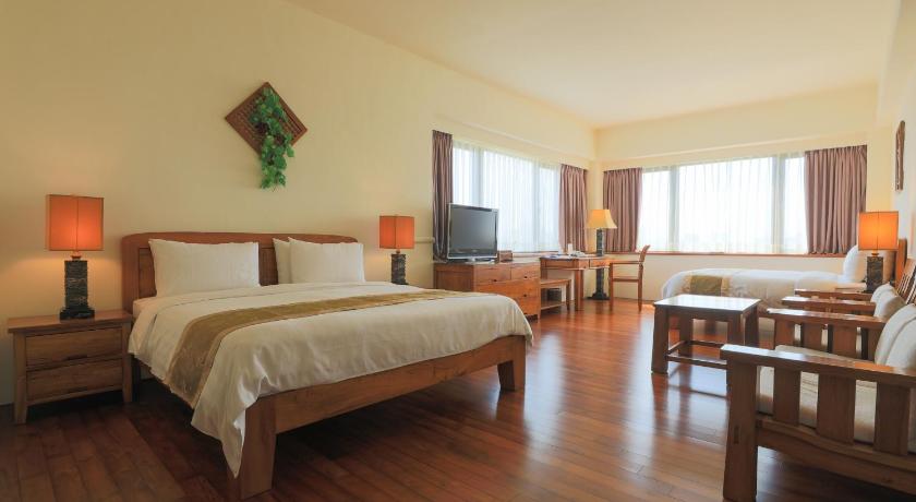 a hotel room with two beds and a desk, Yentai Hotel in Penghu