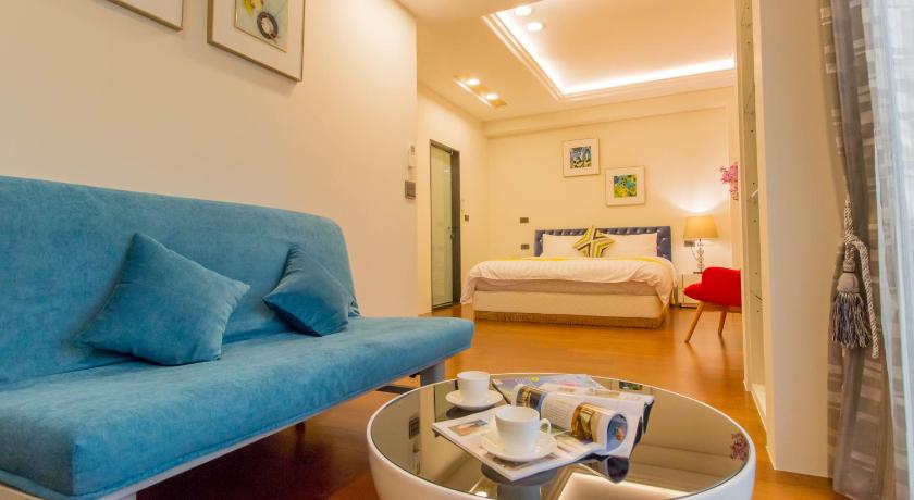 a living room filled with furniture and a blue couch, Hliweng B&B in Yilan