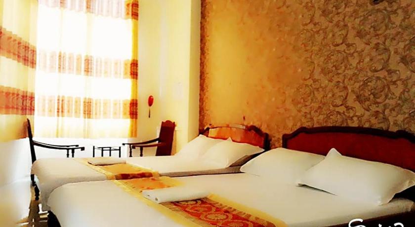 a hotel room with two beds and two lamps, Khach san Duy Hoang in Buon Ma Thuot
