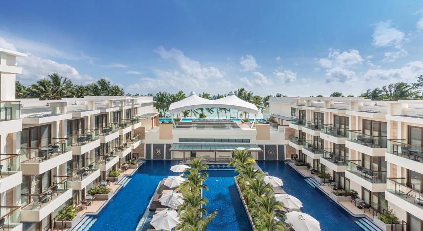a large building with a swimming pool in the middle of it, Henann Palm Beach Resort in Boracay Island