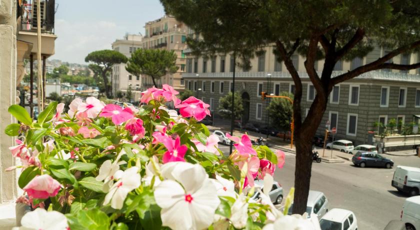 a street filled with lots of flowers next to a tree, Royal Rooms Luxury Suite in Naples