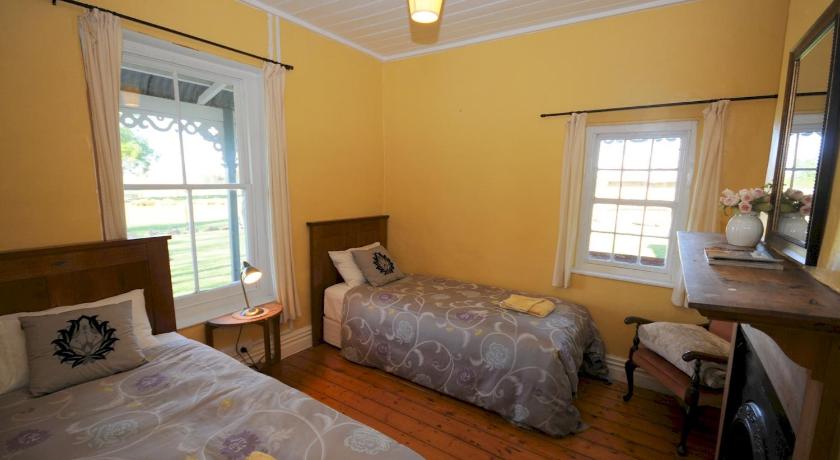 a bed room with two beds and a window, Peter's Farm Lodge in Waipiata