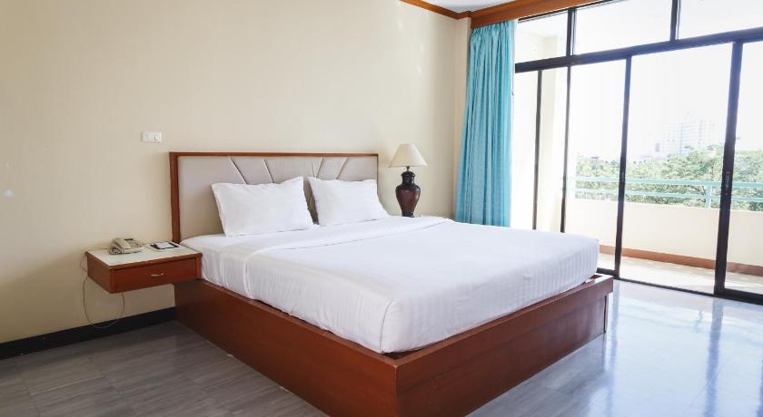 a hotel room with a large bed and a large window, Surin Majestic Hotel in Surin