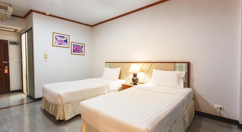 a hotel room with two beds and two lamps, Surin Majestic Hotel in Surin