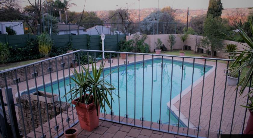 a pool with a pool table and a fence, Moonflower Cottages -Self Catering Apartments in Johannesburg