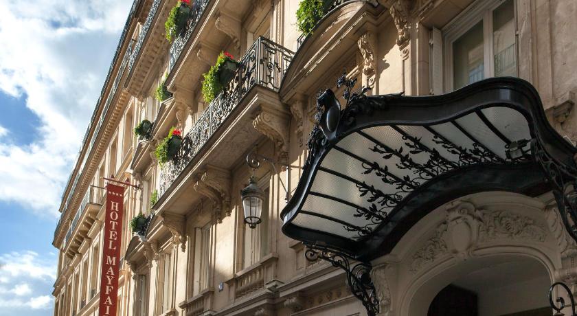 a building with a balcony and a clock on it, Mayfair Hotel in Paris