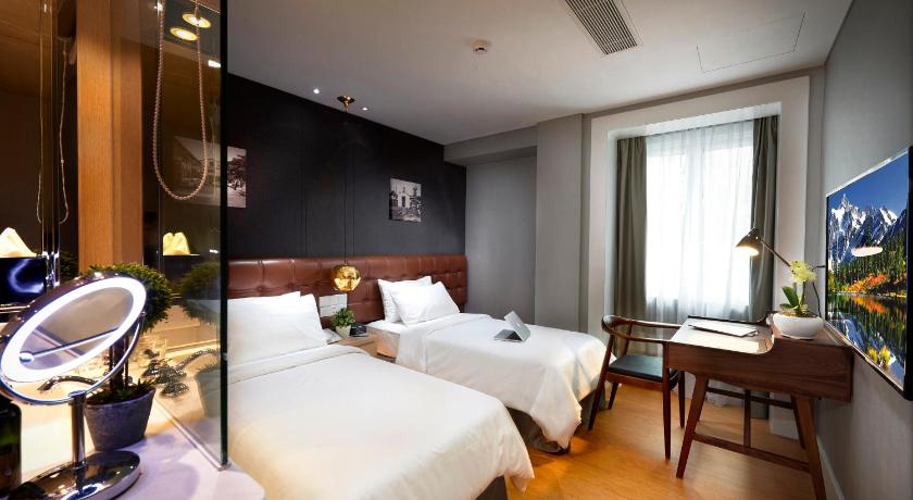 a hotel room with two beds and a television, Kingwood Boutique Hotel in Miri