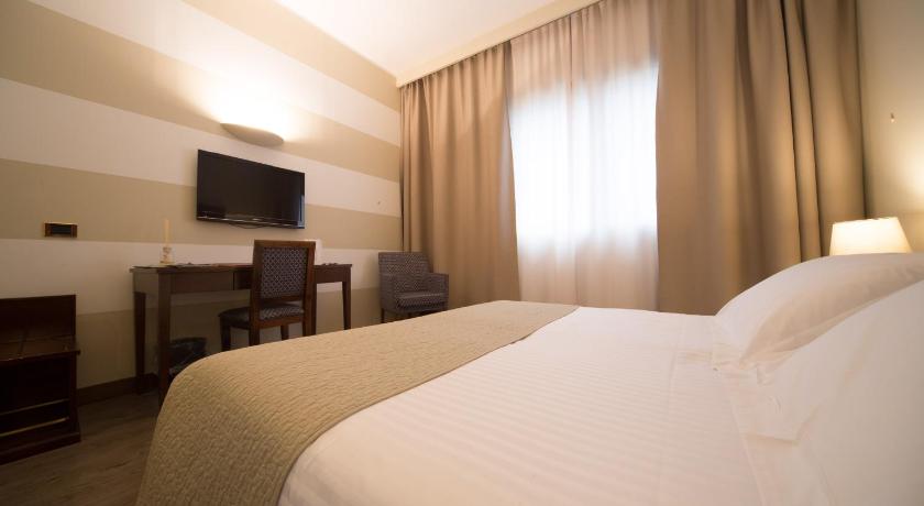 a hotel room with a bed and a television, Hotel Motel Ascot in Lissone