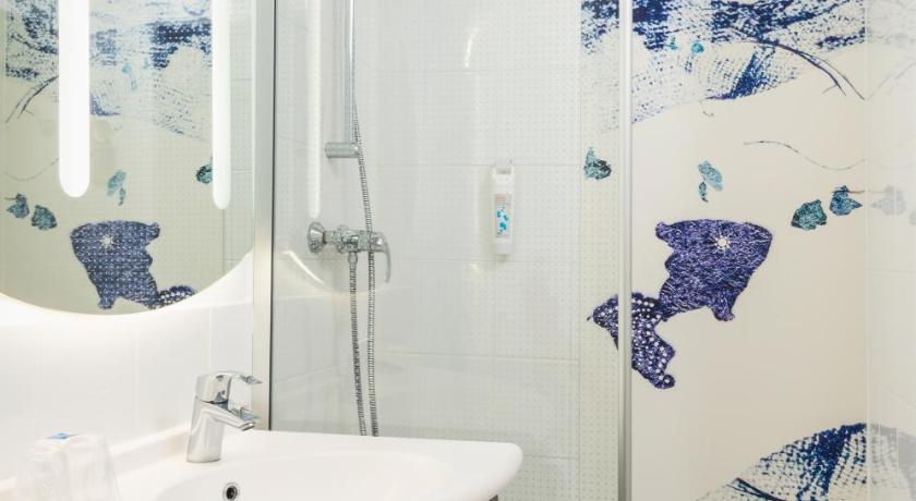 a bathroom with a shower, sink, and mirror, ibis budget Paris Porte de Bercy in Paris