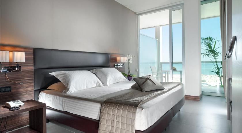 a hotel room with a large bed and a large window, Waldorf Suite Hotel in Rimini