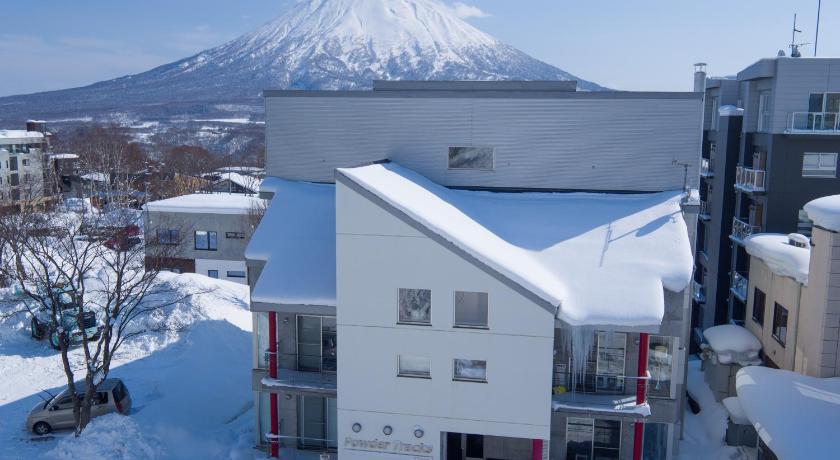 a large building with a snowboard on top of it, Niseko Central Condominiums in Niseko