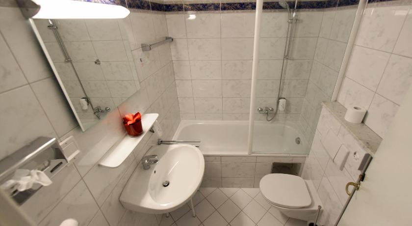 a bathroom with a toilet, sink, and bathtub, Hotel Neutor in Salzburg