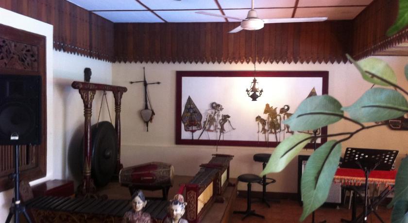 a living room filled with furniture and a painting on the wall, Harmony Inn Yogyakarta in Yogyakarta