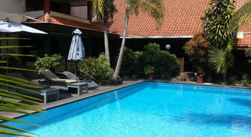 a swimming pool with a pool table in front of it, Harmony Inn Yogyakarta in Yogyakarta