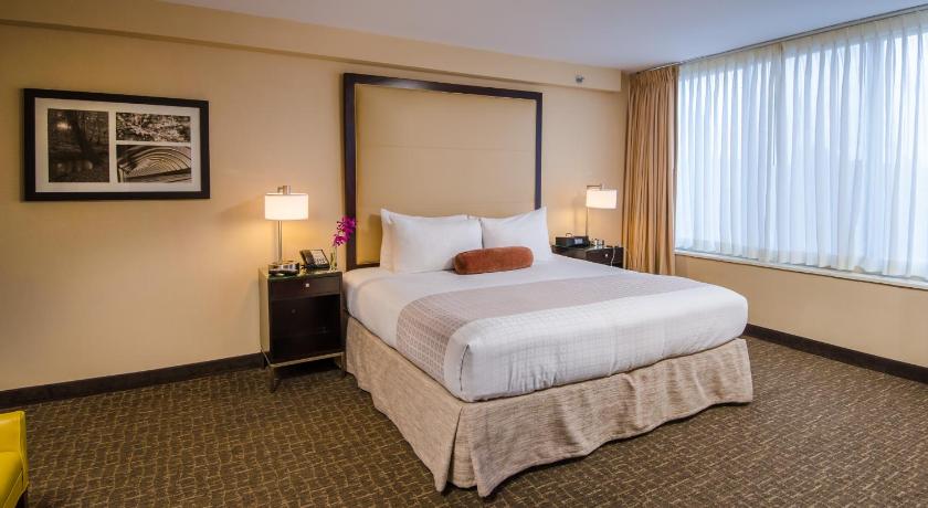 a hotel room with a bed and a dresser, Beacon Hotel and Corporate Quarters in Washington D.C.