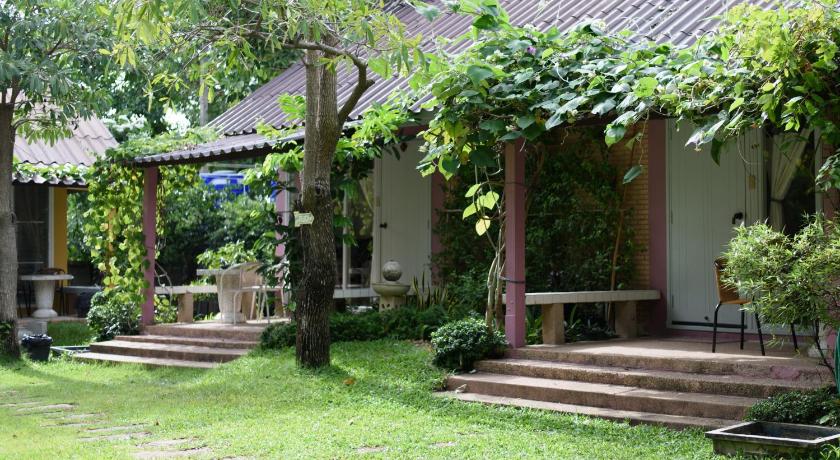 a garden area with a bench and some trees, Baan Kratom Tong by the sea in Hua Hin / Cha-am