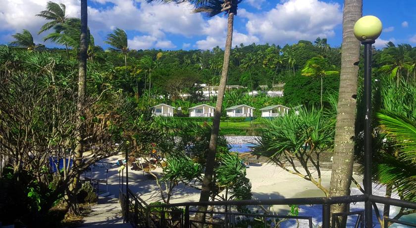 a beach scene with trees and a boat, Golden Tulip Grande Comore Moroni Resort & Spa in Moroni