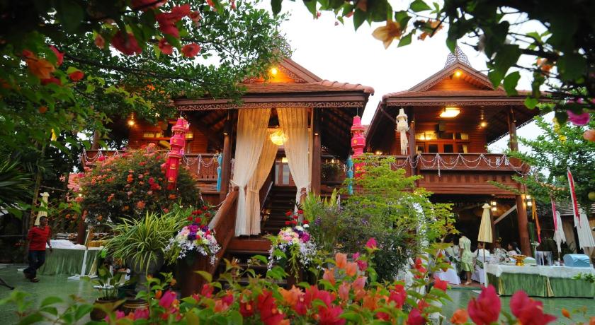 a garden filled with flowers and plants in front of a house, Montri Resort Donmuang Bangkok in Bangkok