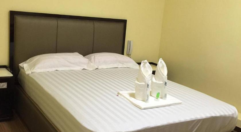 a white bed sitting in a room next to a wall, Meaco Royal Hotel-Plaridel in Plaridel (Bulacan)