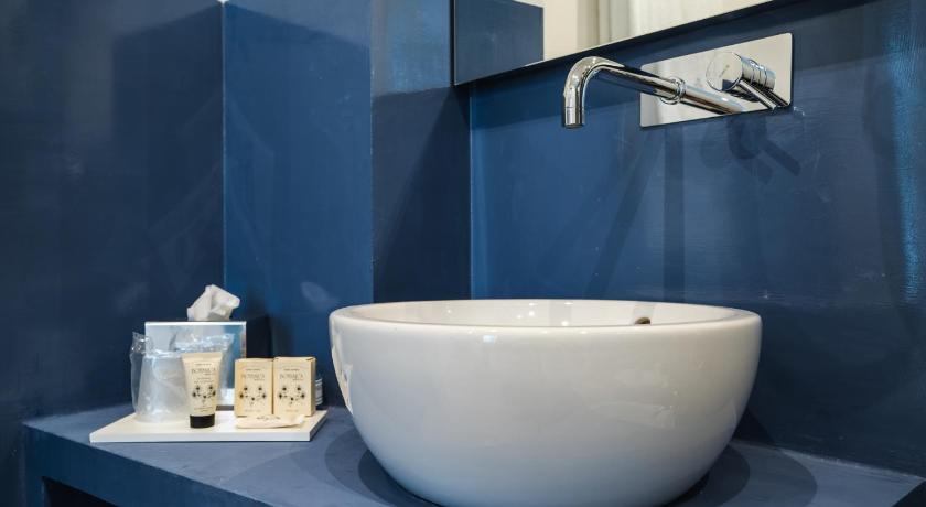 a white sink sitting under a blue wall, Dimora Maio in Monopoli
