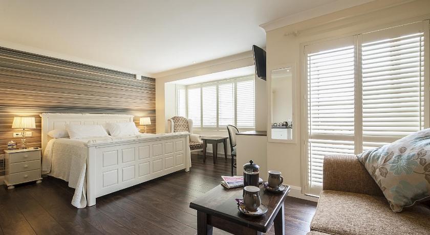 a living room with a bed, table, chairs and a window, Sea Breeze Lodge B&B Galway in Galway