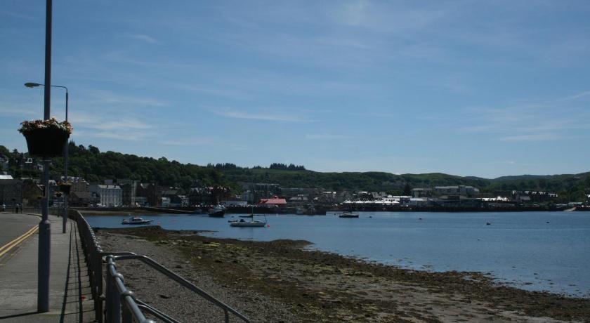 a large body of water with a lighthouse, Oban Youth Hostel in Oban