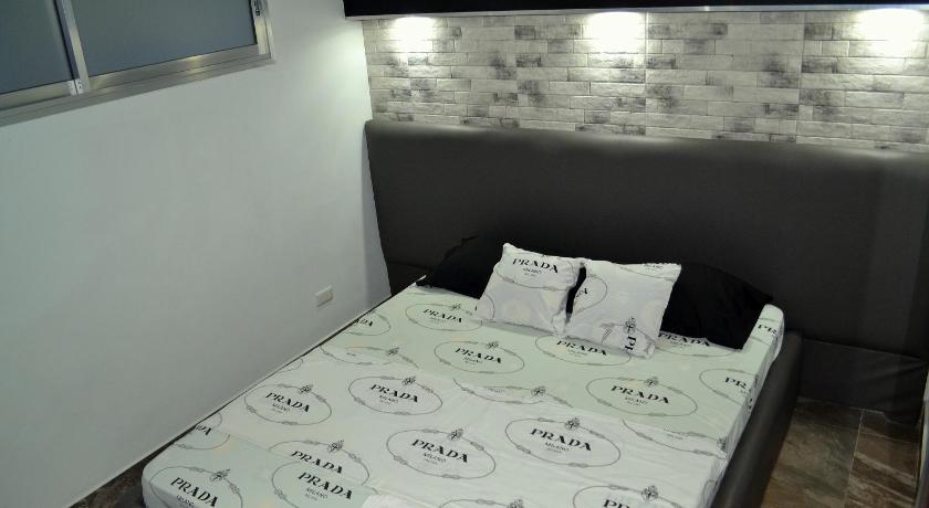 a bed with a white comforter and pillows, Micky Santoro- Apartments in Cebu