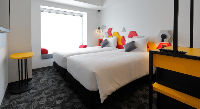 a hotel room with two beds and two lamps, Ibis Styles Tokyo Bay in Tokyo