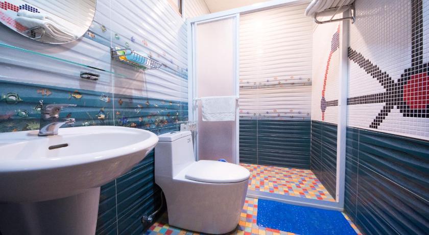 a bathroom with a toilet, sink and tub, Little Apple Bed and Breakfast in Yilan