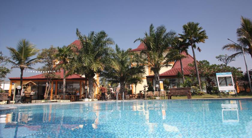 a large swimming pool in a resort with palm trees, Ciptaningati Hotel in Malang