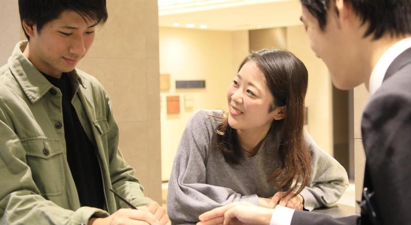 a man and a woman are looking at a paper, Richmond Hotel Higashi Osaka in Higashiosaka