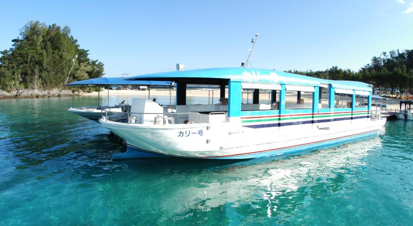 a blue and white boat on the water, Okinawa Kariyushi Beach Resort Ocean Spa in Okinawa Main island