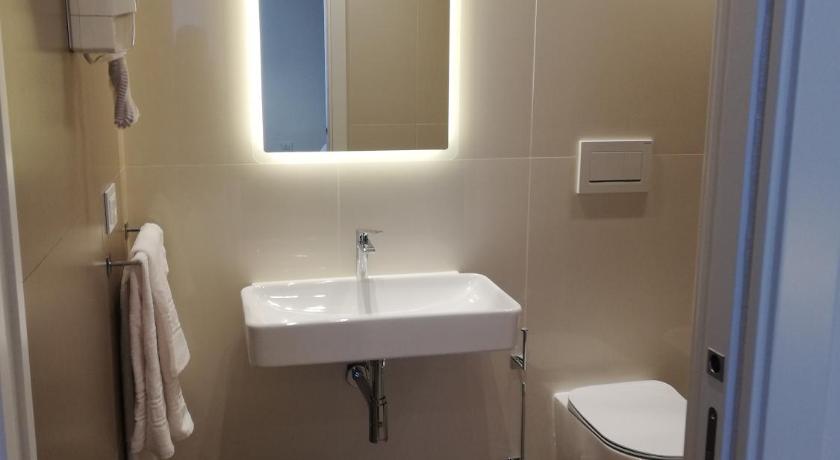 a white toilet sitting next to a white sink, Maison Saint Honore in Foggia