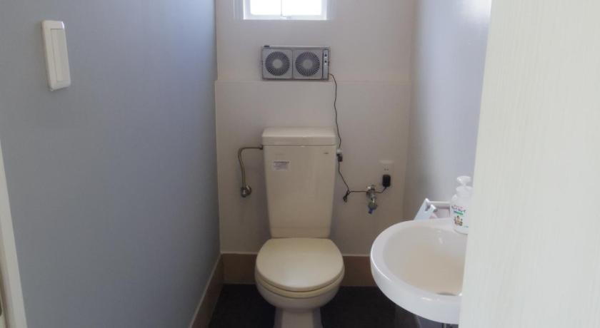 a white toilet sitting next to a sink in a bathroom, ウィークリー・マンスリー SORA in Miyakojima