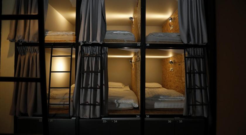 two beds in a room with a window, Sleepbox Hotel in Cameron Highlands